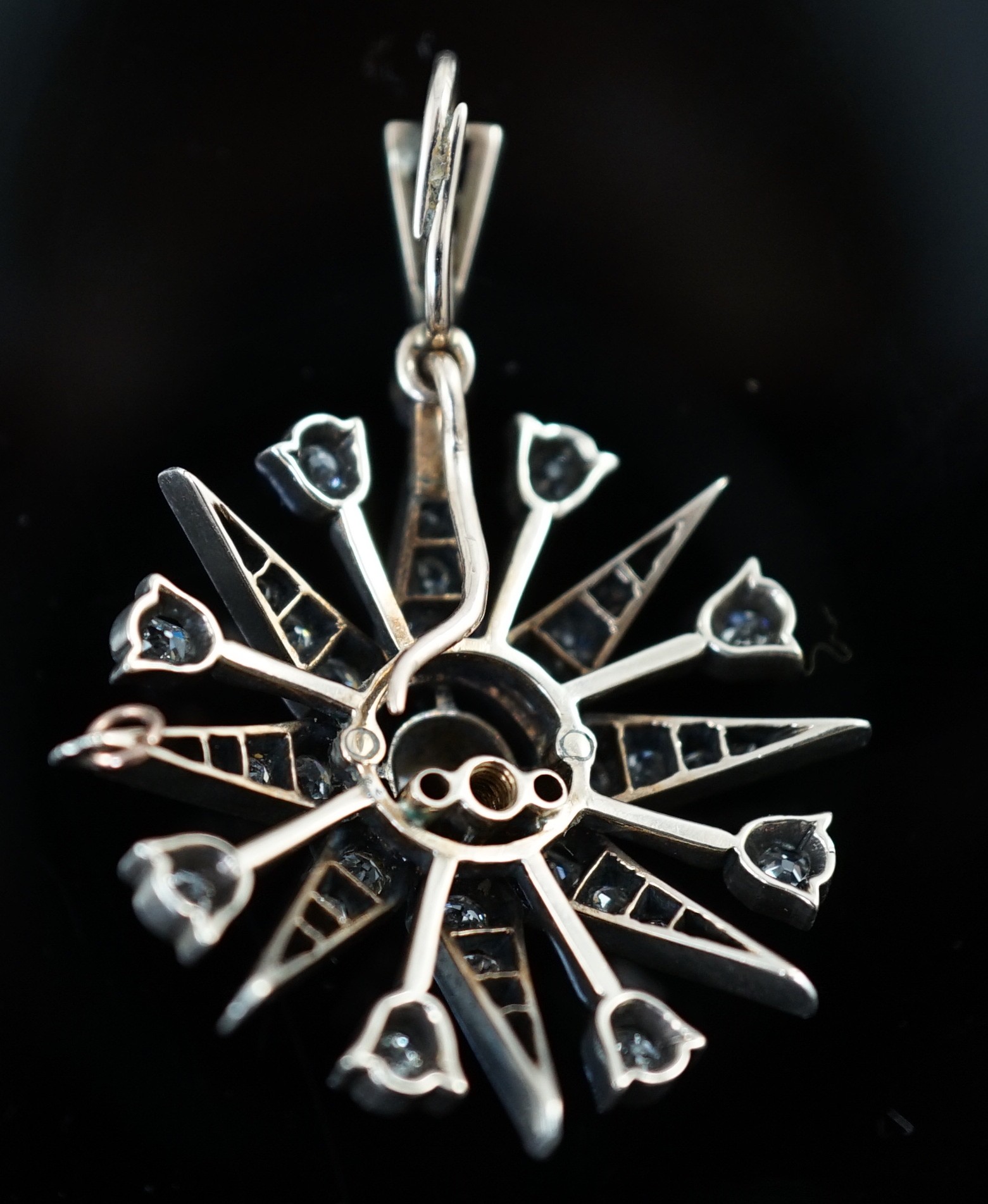 A late Victorian gold, silver and diamond cluster set starburst pendant